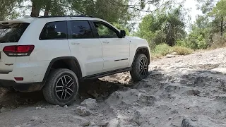 Grand Cherokee Trailhawk climbing up a powder-covered rocky sloap