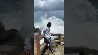 Wave Knocks Down Person Taking Photo at Seashore