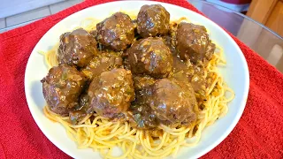 Meatballs smothered in gravy over seasoned spaghetti