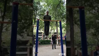 A strong old Chinese man rocked the crowd by doing pull-ups.