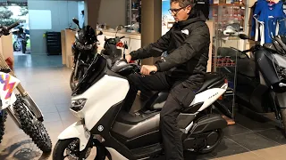 Tall man sitting on small YAMAHA NMAX 125cc scooter 2024