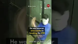 A masked thief tries to break into an ATM