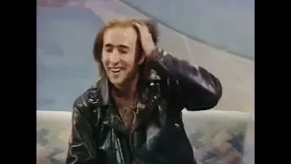 Nicolas Cage’s gets a bit wild & odd during a 1990 talk show. He entry with a somersault and kicks!
