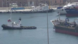 A small tanker is towed for docking at the Port of Piraeus, Greece