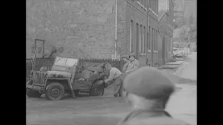 GIs trying to clean their Jeep splashed by passing traffic in Zweifall in 1945