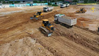 Dump Trucks Pouring Out Soil And Dozers Push The Soil Flat