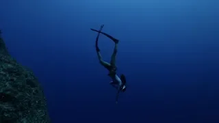 Freediving along the 80 meter depth drop-off in Tinian islands