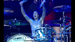 Travis Barker drumming in an upside down cage