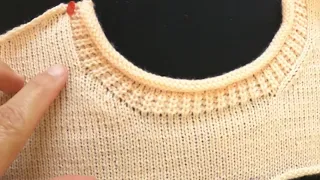 detalhes no decote redondo feito em máquina de tricô