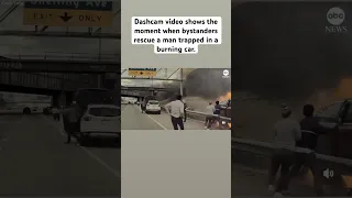 Dashcam video shows the heroic moment when bystanders rescue a man trapped in a burning car.