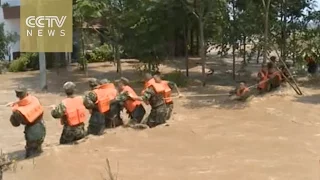 China floods: 21,000 evacuated after levee breaks in central China