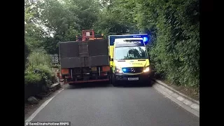 Ambulance on emergency left wedged against fierengine stuggle the village