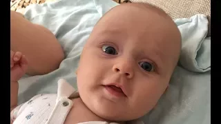 Малыш улыбается, смотря на маму. The kid is smiling