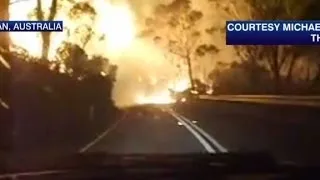 Firefighter drives through huge flames