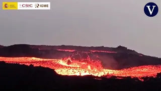 Una geóloga se acerca a un gran bloque de lava descendiendo por una colada en La Palma