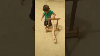 Taking first steps with the help of wooden walker