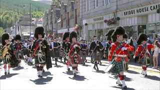 Drum Majors lead the combined Pipe Bands over river Dee marching to 2022 Ballater Highland Games