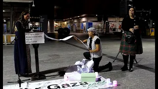 'Praying for Gaza' Brisbane inter-faith vigil: rolling the scroll of children's names to a bagpiper