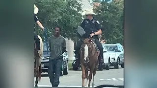 TX: Photo of mounted police officers leading black man through streets by rope