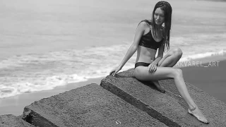 Girl with a surf on a black beach