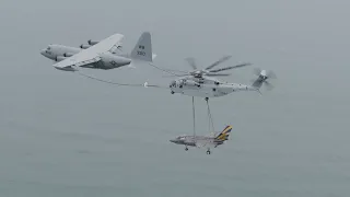 Marine CH-53K lifts a F-35C while refueling from a KC-130