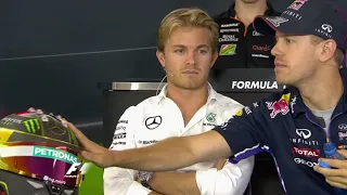 Rosberg visibly disappointed while Vettel inspects his helmet
