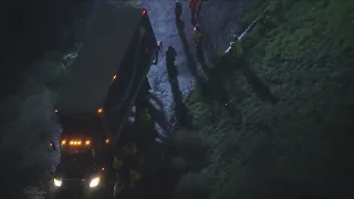 Stuck delivery truck threatening homes below