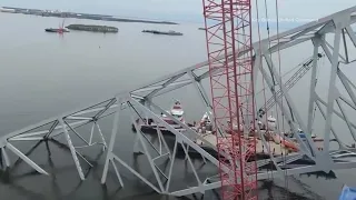 Salvage crews work to remove large section of Francis Scott Key Bridge from atop cargo ship