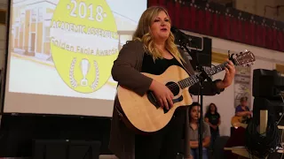 Capital High Graduate Maddie Zahm returns to her alma mater to perform during academic assembly.