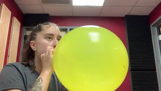 My friend Jessica blowing up a yellow balloon to pop brand new video