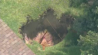 15-foot-deep hole growing between homes