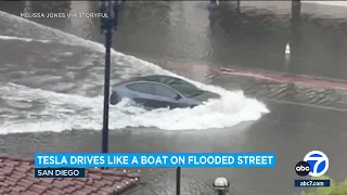 Tesla car plows through flooded San Diego street