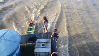 Crianças se arriscam vendendo e pedindo alimentos em barcos no rio Amazonas