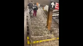 Water gushes down subway stairs during flooding in NYC