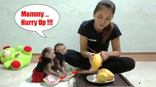 Mimi Kuku holds a bowl and waits for Mom to share the mango