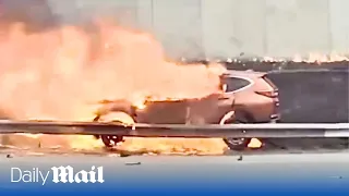 Terrifying moment a man is saved from a burning car after group of Good Samaritans rush to his aid