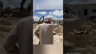 Palestinian man recites call to prayer in front of Israeli bulldozers