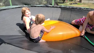 Water balloon on trampoline popping in slow motion.