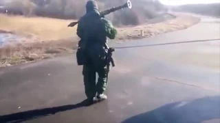 A pro Russian separatist firing an 82mm mortar round with an RPG launcher in Ukraine