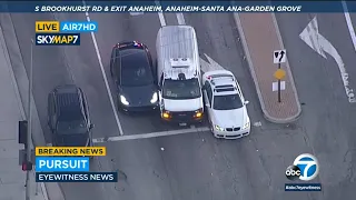 Suspect wedges stolen van between 2 cars to get through busy traffic during chase