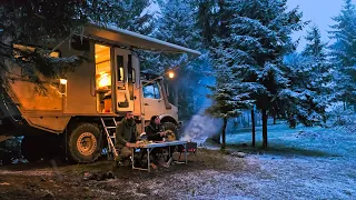 SNOW CAMP WITH A CARAVAN IN THE FOG-COVERED FOREST