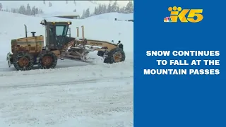 Snow continues to fall at the passes