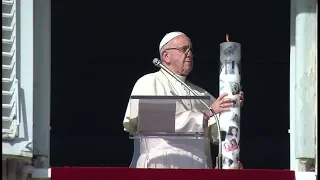 Papa accende una delle migliaia di candele della campagna mondiale per i cristiani in Siria