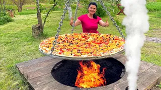 Giant pizza in a huge tandoor: cooking on an open fire