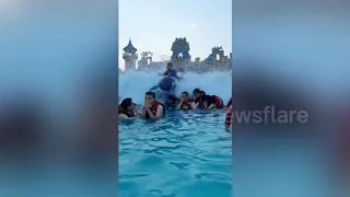 Chinese man on inflatable dolphin flies over crowds at water park's wave machine