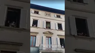 Italians praising God from their windows, singing the song, "How great is our God."