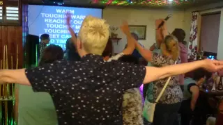 Club patrons singing  Sweet Caroline originally recorded by Neil Diamond