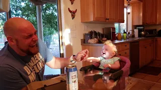 Laughing baby plays drop the pacifier with her father