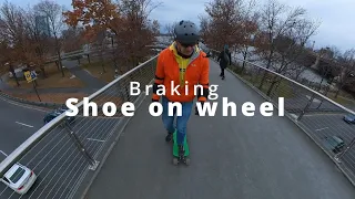 Shoe on exposed wheel braking on an LDP longboard setup. November 2021 in Boston.