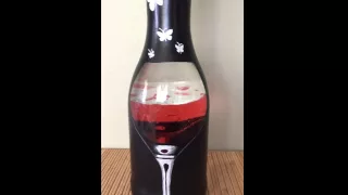 Large wine bottle with clear wine glass and tealight